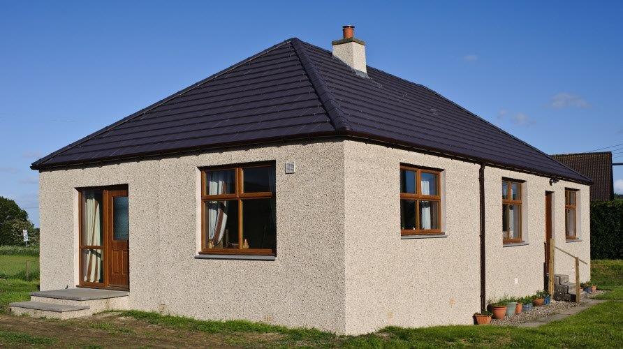 Roofer replacing broken tiles on a storm-damaged roof